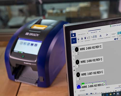 Le logiciel de création d’étiquettes au premier plan et l’imprimante i5300 en arrière-plan.