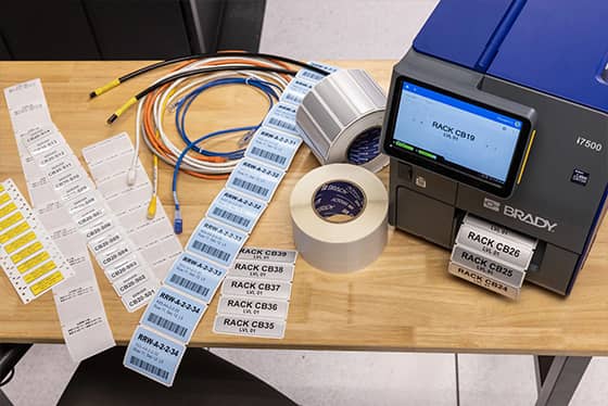 Un employé applique une étiquette de suivi de bien sur un ordinateur portable.