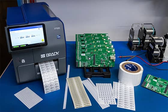 Un employé applique une étiquette de suivi de bien sur un ordinateur portable.