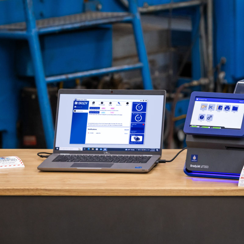 Un ordinateur portable connecté à une imprimante J7300 affiche un écran de Brady Workstation.