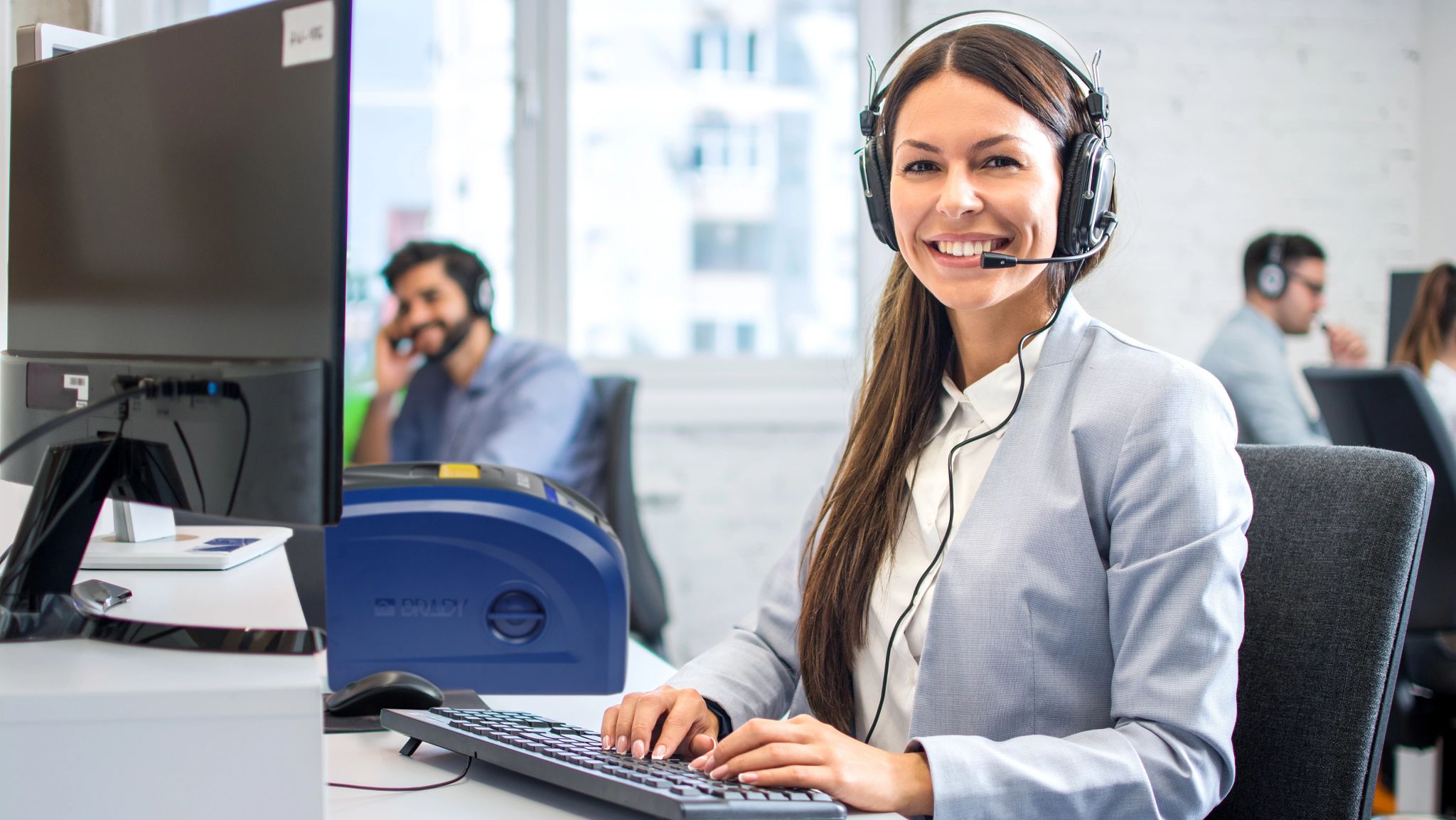 Une personne tenant un téléphone. L’écran du téléphone affiche une étiquette jaune vif créée à l’aide de l’application mobile Express Labels. À l’arrière-plan, on voit un bac en plastique sur lequel se trouve l’étiquette imprimée.